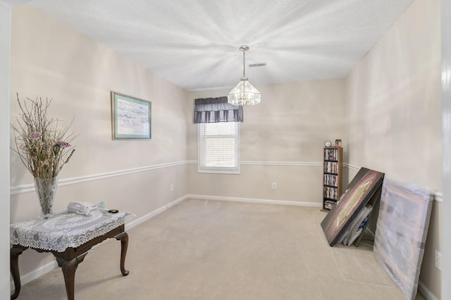 living area with carpet floors, visible vents, a notable chandelier, and baseboards