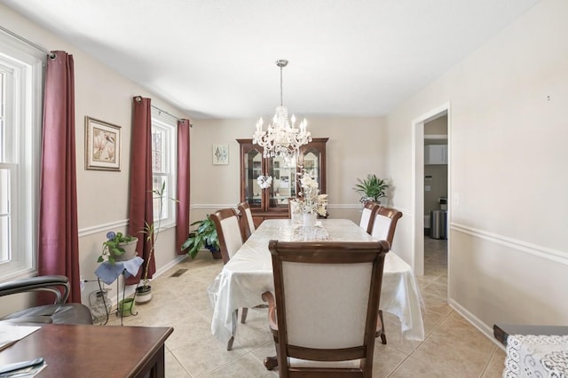 dining room with baseboards, light tile patterned flooring, and an inviting chandelier