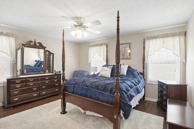 bedroom featuring dark wood-style floors, baseboards, and a ceiling fan