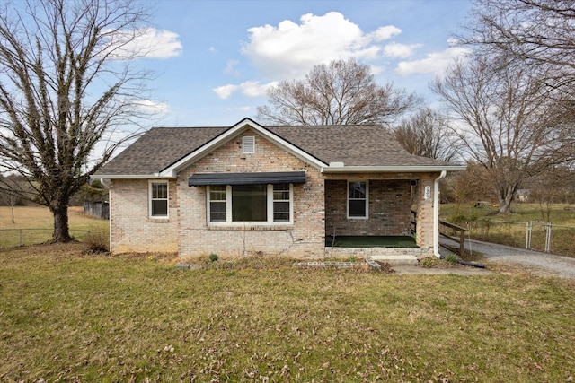 view of front of house with brick siding, fence, and a front yard