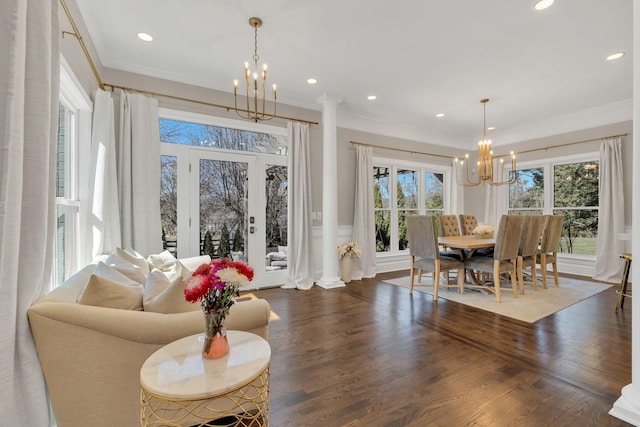 dining area with an inviting chandelier, crown molding, and wood finished floors