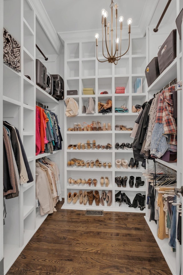 walk in closet featuring visible vents, a notable chandelier, and wood finished floors