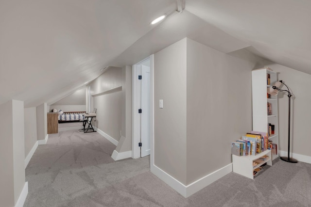 additional living space featuring carpet floors, baseboards, and vaulted ceiling