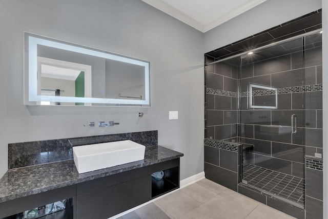 bathroom with a stall shower, tile patterned flooring, vanity, and baseboards