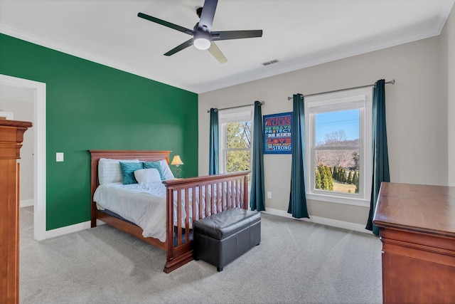 carpeted bedroom with ceiling fan, ornamental molding, visible vents, and baseboards