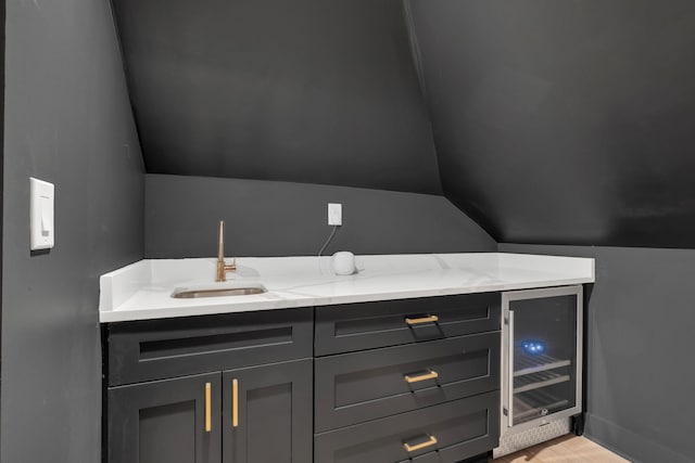 bathroom with beverage cooler, vaulted ceiling, vanity, and baseboards