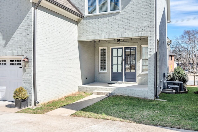 5704 Old Harding Pike, Nashville, TN 37205 - doorway to property with central air condition unit, a garage, brick siding, and a lawn