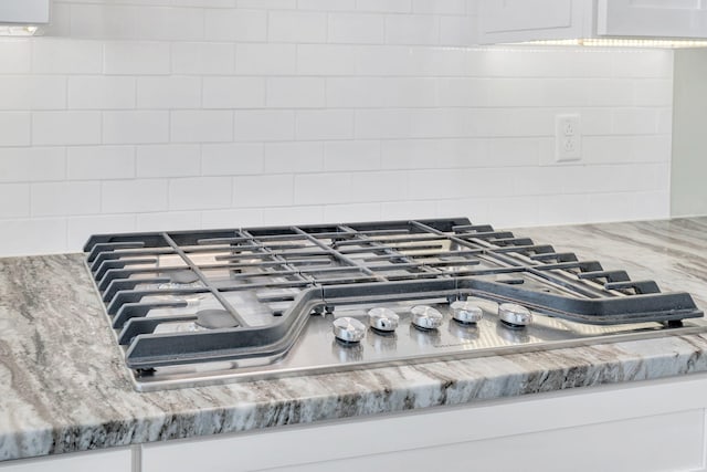 5704 Old Harding Pike, Nashville, TN 37205 - interior details with white cabinets, stainless steel gas stovetop, light stone countertops, and backsplash