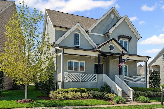 5704 Old Harding Pike, Nashville, TN 37205 - view of front facade featuring covered porch, a shingled roof, brick siding, and a front yard