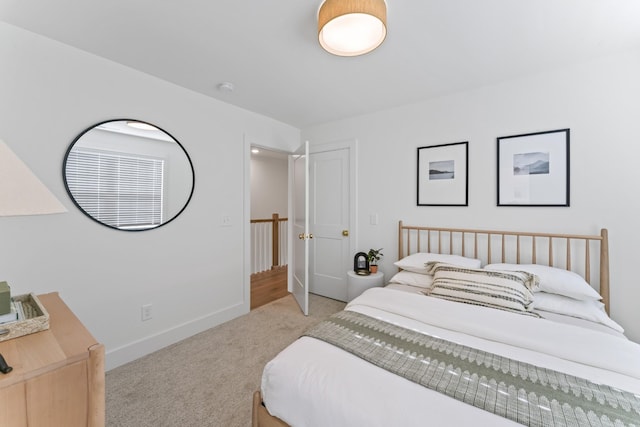 bedroom with baseboards and light colored carpet