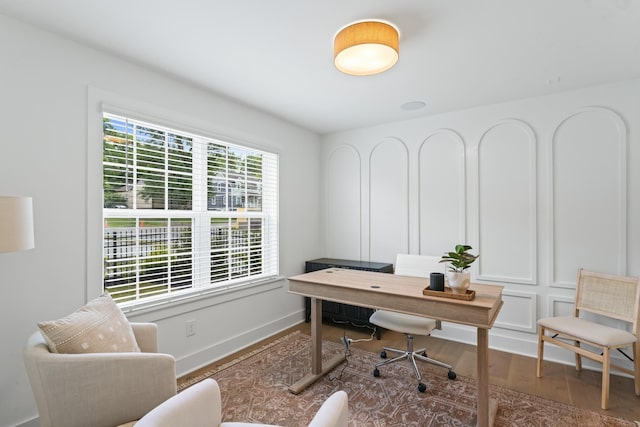 home office with baseboards and wood finished floors