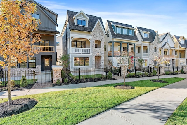 view of front of home featuring stone siding, a fenced front yard, and a residential view