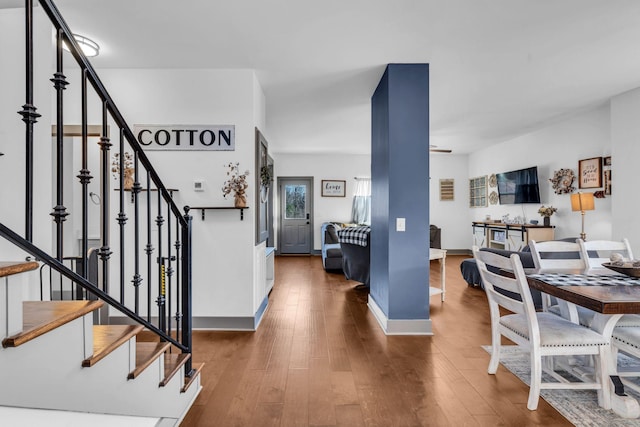 foyer entrance featuring stairs, hardwood / wood-style flooring, and baseboards