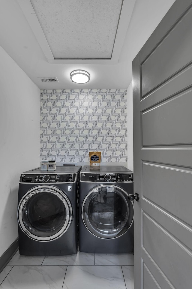 clothes washing area with marble finish floor, laundry area, separate washer and dryer, and visible vents