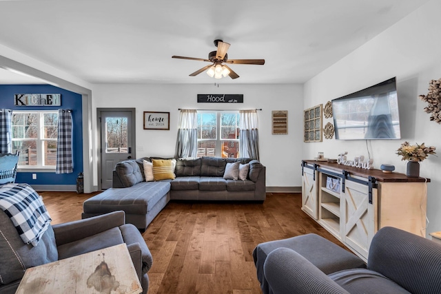 living room with plenty of natural light, wood finished floors, and a ceiling fan