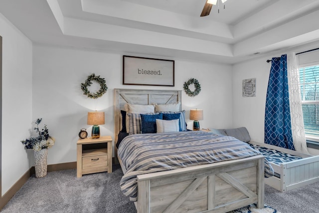 bedroom with ceiling fan, carpet floors, visible vents, baseboards, and a raised ceiling