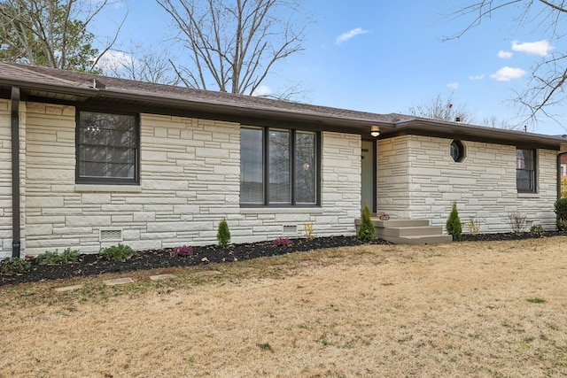 ranch-style house with a shingled roof, crawl space, and a front lawn