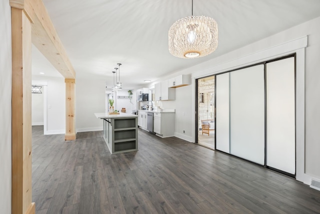 kitchen featuring dark wood-style flooring, open shelves, light countertops, stainless steel dishwasher, and white cabinetry