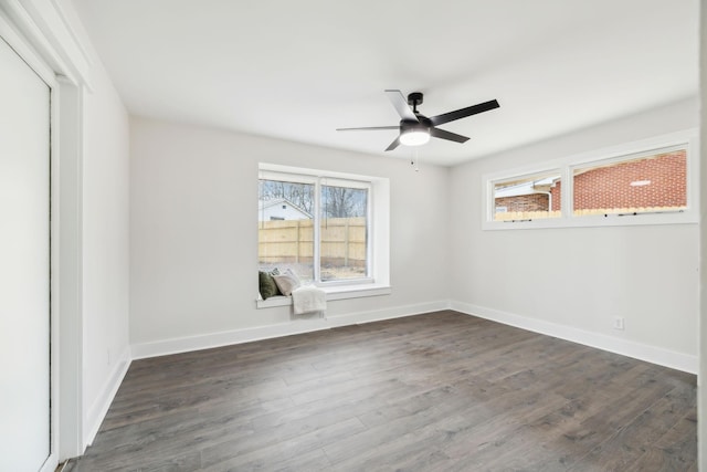 empty room featuring dark wood-style floors, ceiling fan, and baseboards