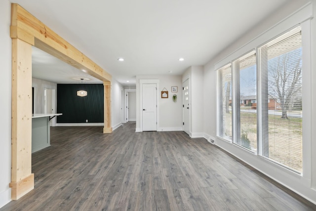 unfurnished living room with visible vents, baseboards, dark wood-type flooring, and recessed lighting