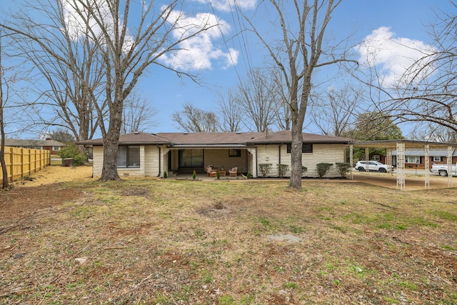 rear view of property with a lawn and fence