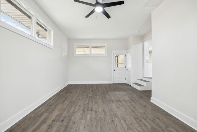 unfurnished room with ceiling fan, dark wood finished floors, and baseboards