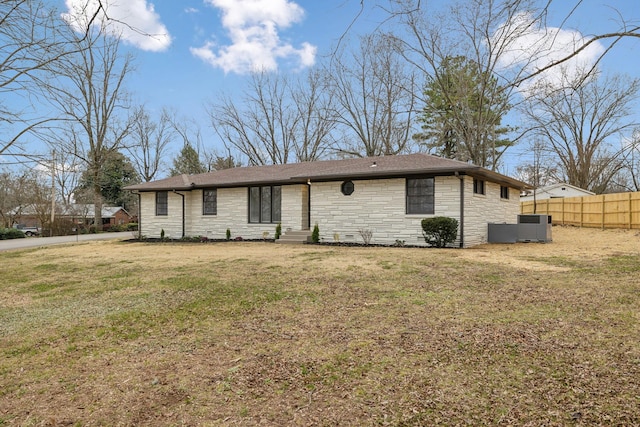 view of front facade featuring a front yard, stone siding, and fence