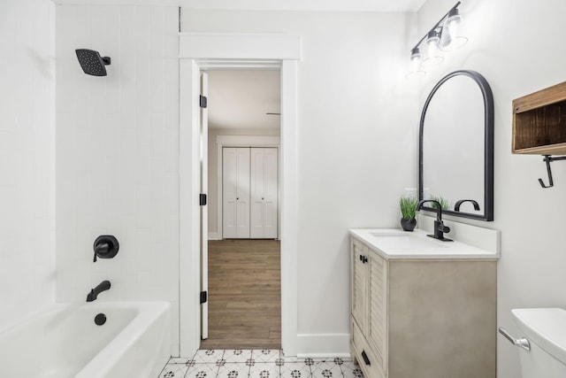 full bath with bathing tub / shower combination, toilet, vanity, baseboards, and tile patterned floors