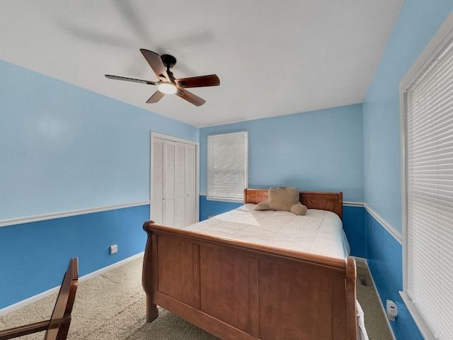 carpeted bedroom with a closet, a ceiling fan, and baseboards