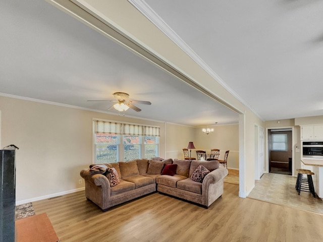 living room featuring ornamental molding, light wood finished floors, ceiling fan with notable chandelier, and baseboards