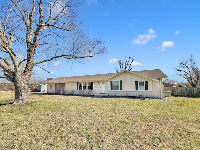 ranch-style home with a front yard, brick siding, and fence