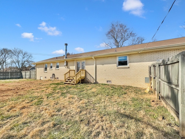 back of property featuring entry steps, a lawn, crawl space, fence, and brick siding