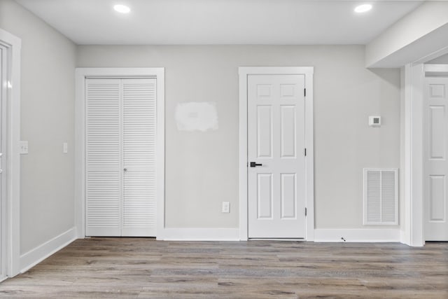 unfurnished bedroom with baseboards, visible vents, wood finished floors, and recessed lighting