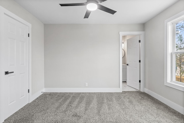 unfurnished bedroom featuring carpet, multiple windows, ceiling fan, and baseboards