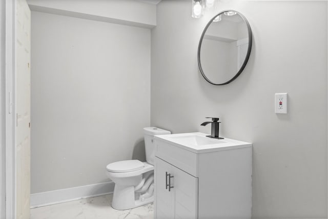 bathroom with toilet, marble finish floor, baseboards, and vanity