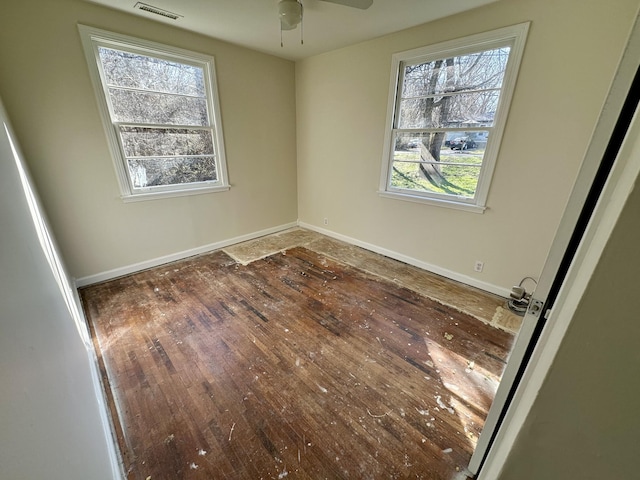 unfurnished bedroom featuring baseboards, visible vents, and hardwood / wood-style floors