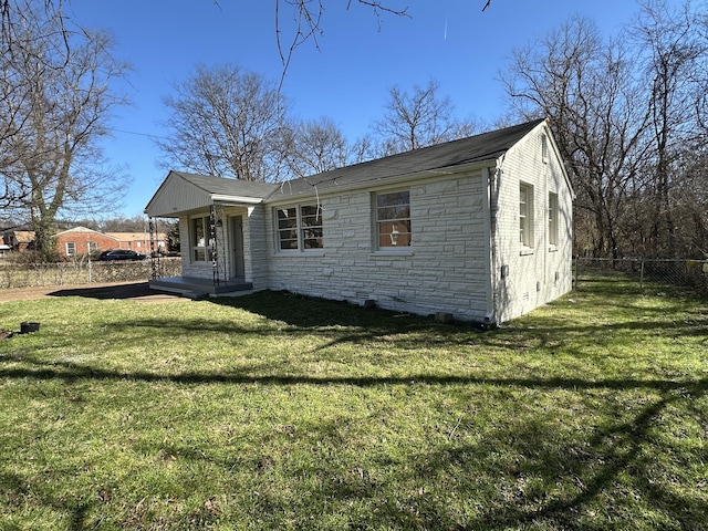 view of front facade featuring stone siding, a front lawn, and fence