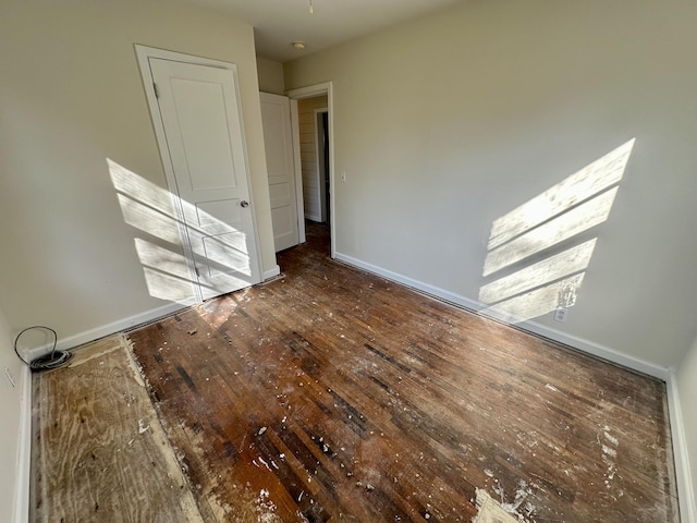 empty room featuring wood-type flooring and baseboards