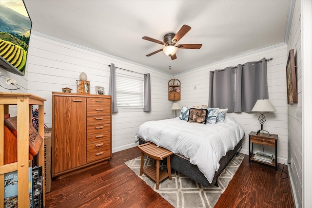 bedroom featuring a ceiling fan, ornamental molding, baseboards, and wood finished floors