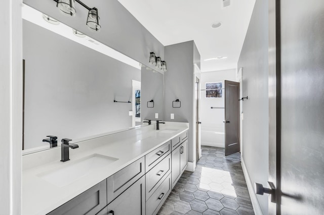 full bath featuring double vanity, baseboards, a sink, and tile patterned floors