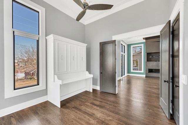 mudroom with a ceiling fan, a fireplace, dark wood finished floors, and baseboards