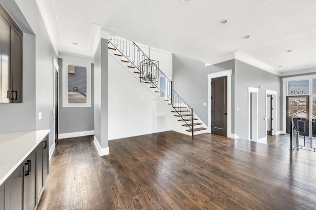 entryway with crown molding, stairway, and wood finished floors