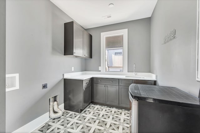 laundry room with light floors, visible vents, cabinet space, a sink, and electric dryer hookup