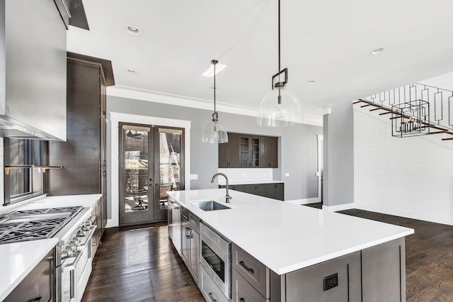 kitchen with light countertops, appliances with stainless steel finishes, dark wood-style flooring, and a sink