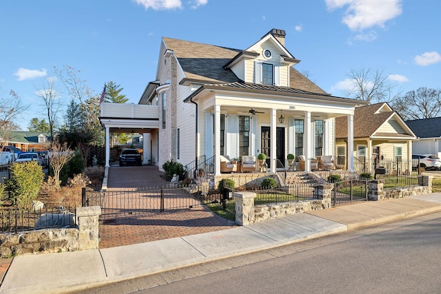 view of front of property featuring a fenced front yard, a porch, a standing seam roof, metal roof, and ceiling fan