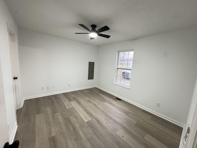 unfurnished bedroom with dark wood-style floors, electric panel, visible vents, and baseboards