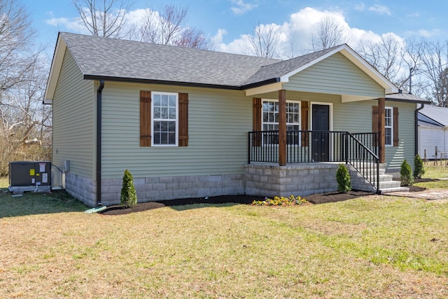 view of front of property with covered porch, roof with shingles, and a front lawn