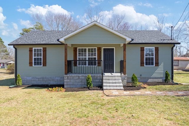 view of front of property with covered porch, a front lawn, and roof with shingles