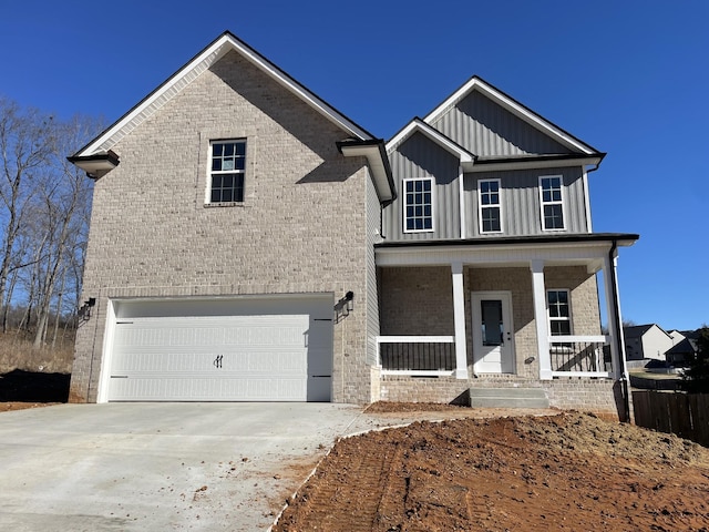 view of front of house featuring brick siding, covered porch, board and batten siding, a garage, and driveway