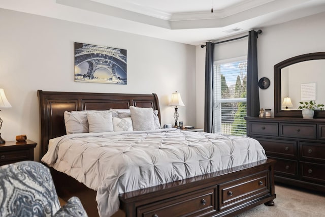 bedroom with crown molding, a tray ceiling, visible vents, and light colored carpet